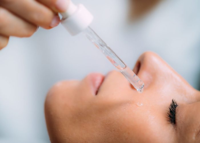 Cosmetician Applying Hyaluronic Acid Serum on Woman’s Face